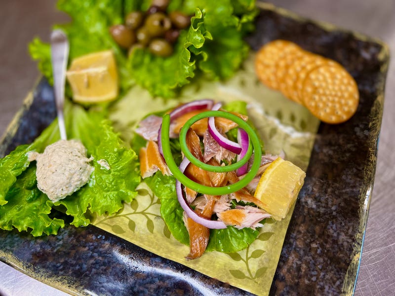 Smoked Trout appetizer with horseradish, olives, and onions.