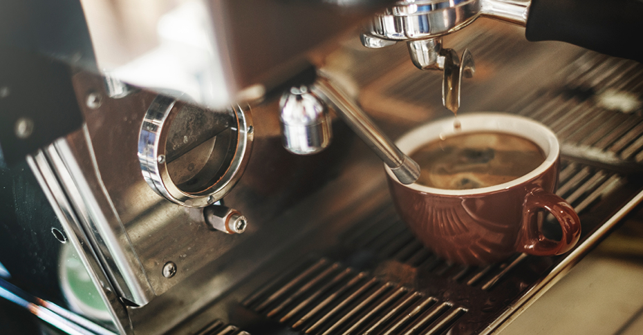 Espresso machine dripping espresso into brown coffee cup - sorso coffee
