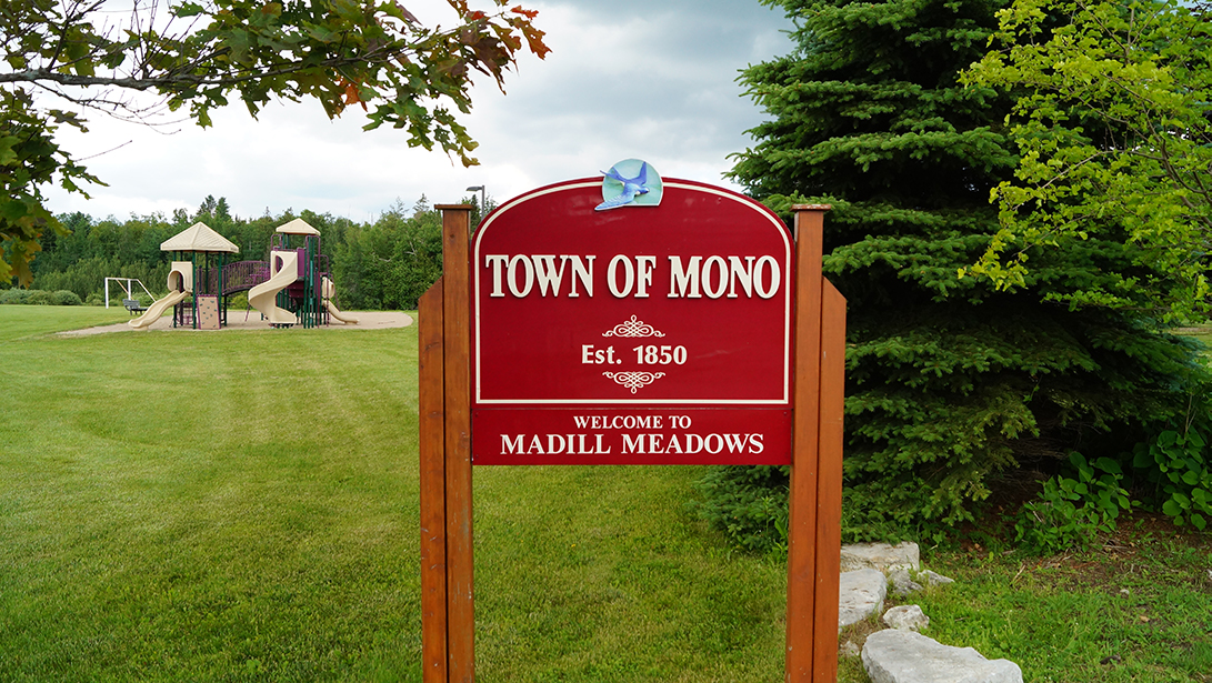 Gateway sign at Madill Meadows Park with playground and soccer net in background