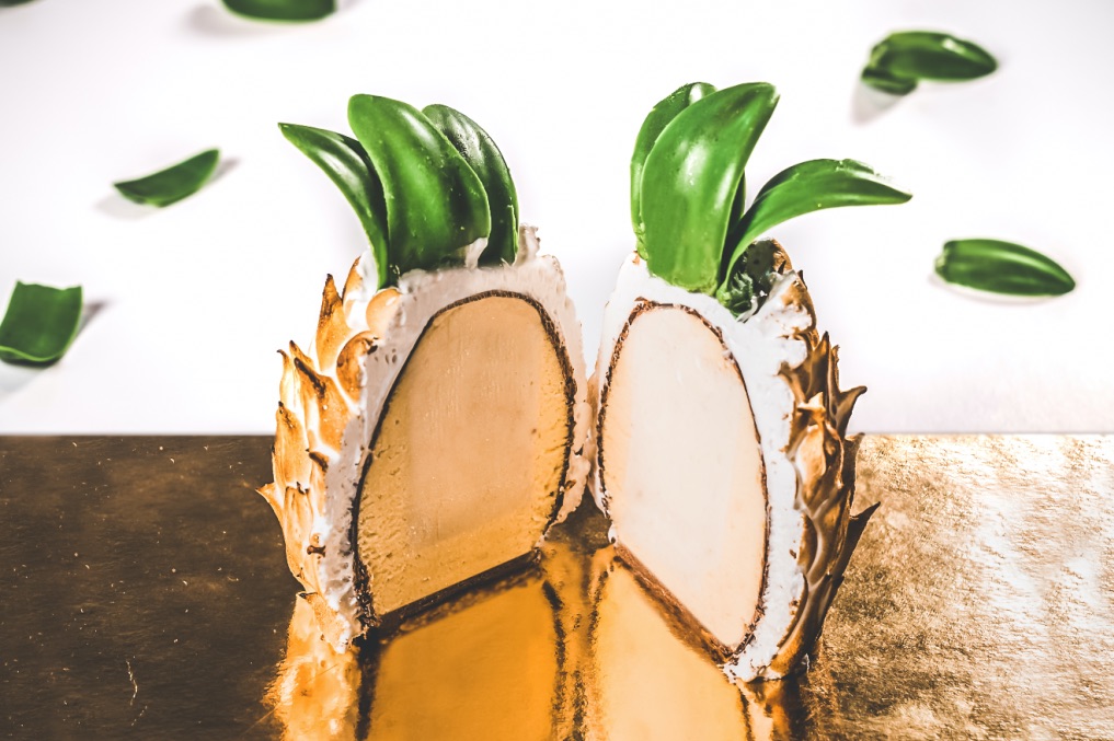 custom Pina Banana gelato cake - Banana and miso gelato is surrounded by passionfruit mousse, sitting on a bed of chocolate sponge – all enrobed in milk chocolate and finished with passionfruit Italian meringue and chocolate leaves
