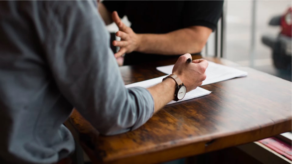 Two people involved in a discussion and going through documents