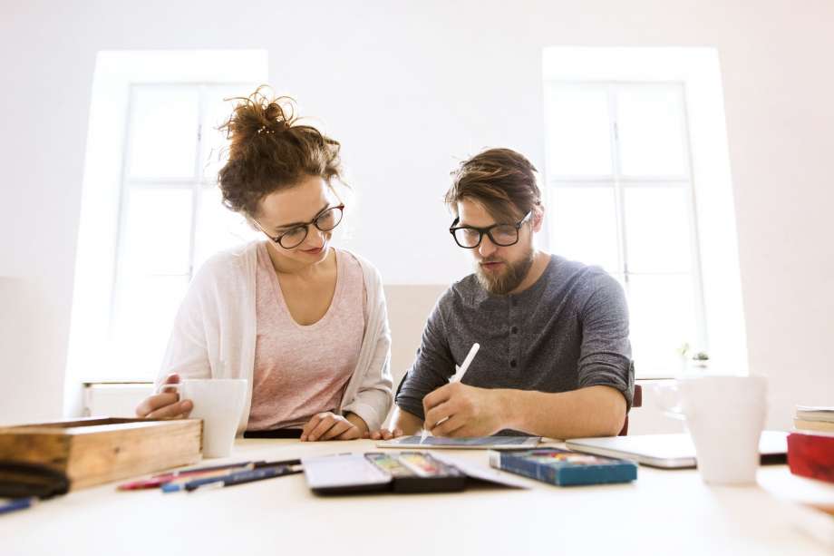 Two people working on an iPad