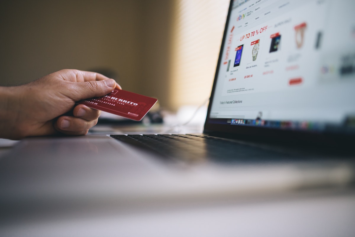 A person using their card while looking for things to buy online