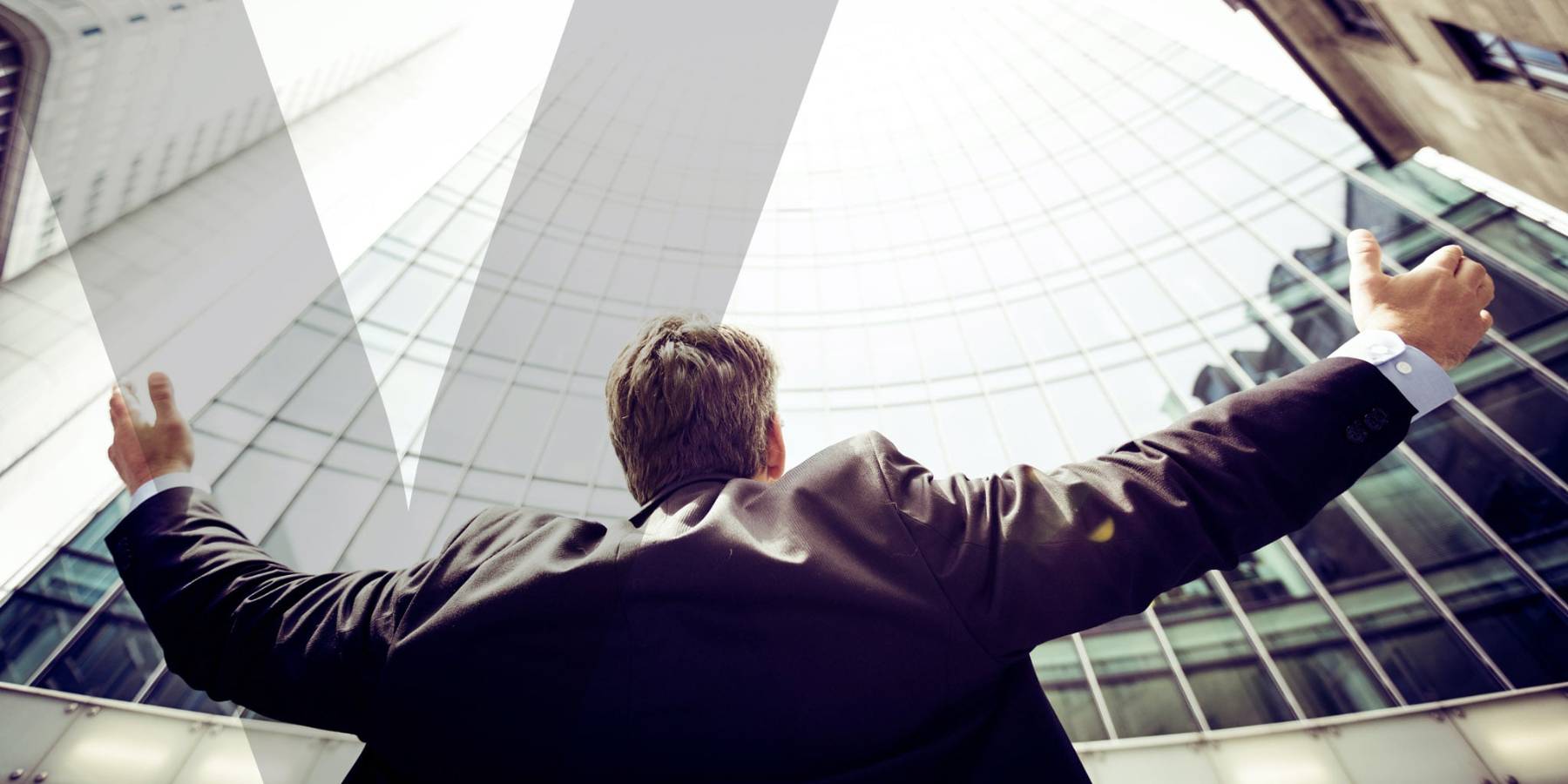 A person in front of a tall building with his arms stretched wide