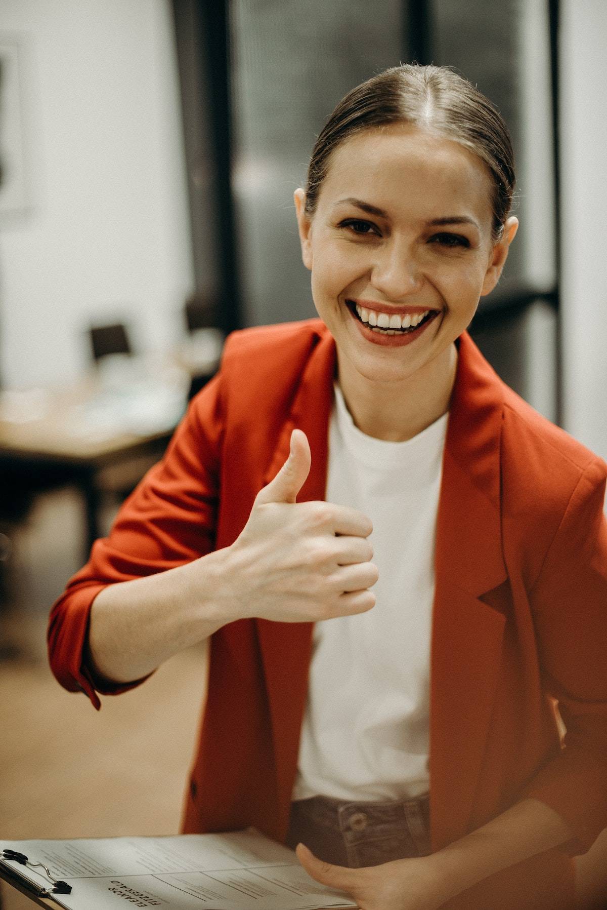 A woman smiling and giving the thumbs up