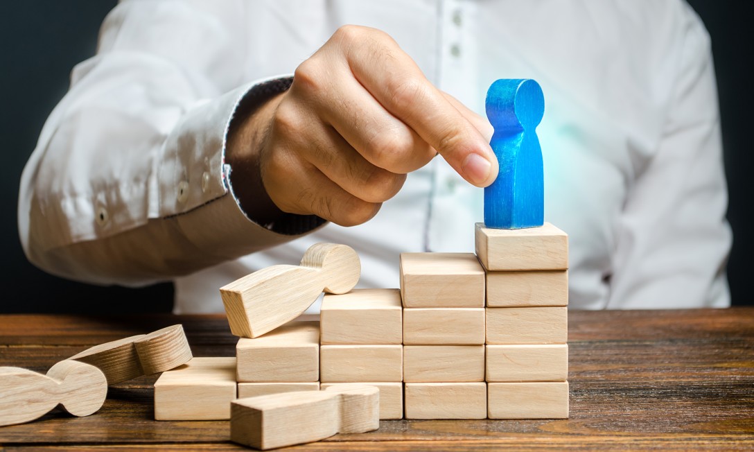A man highlighting a blue meeple among various others