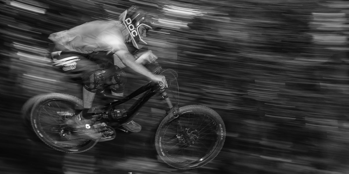 A Person riding a mountain bike down hill with blurred back ground