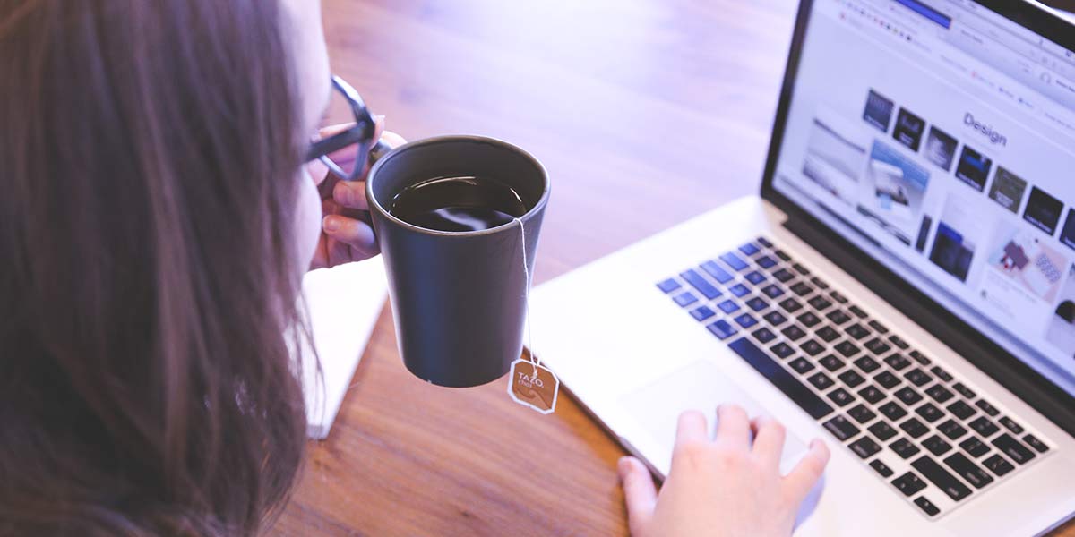 A person drinking Tea and using a laptop
