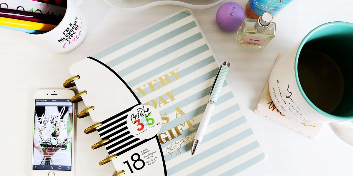 A note pad, mobile, cup of Coffee and pens on a desk