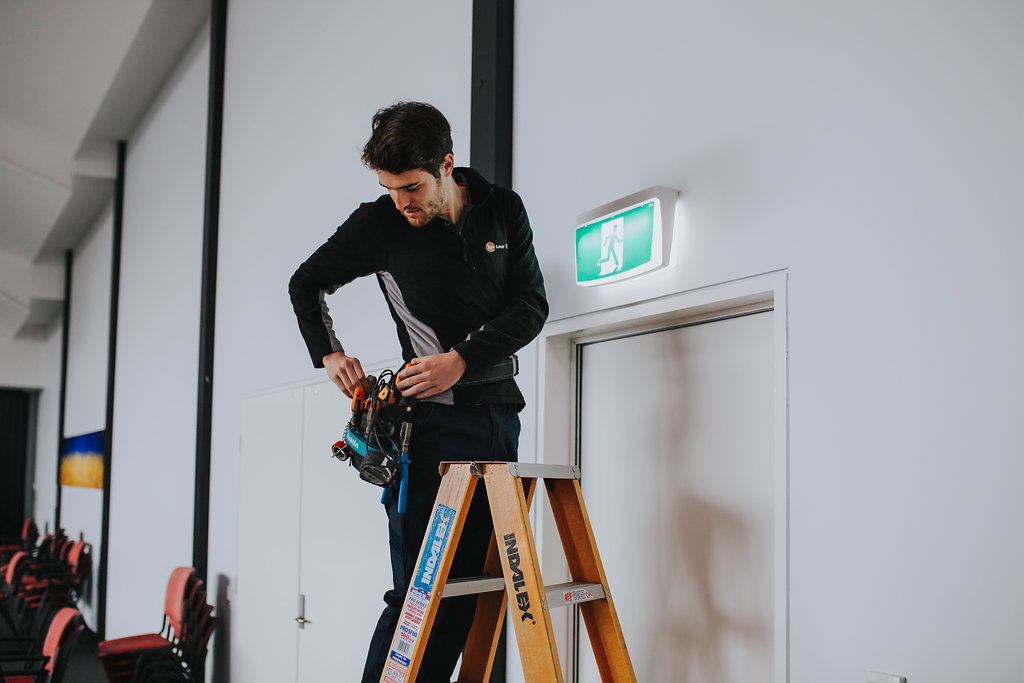 Commercial Electrician doing testing on emergency lighting