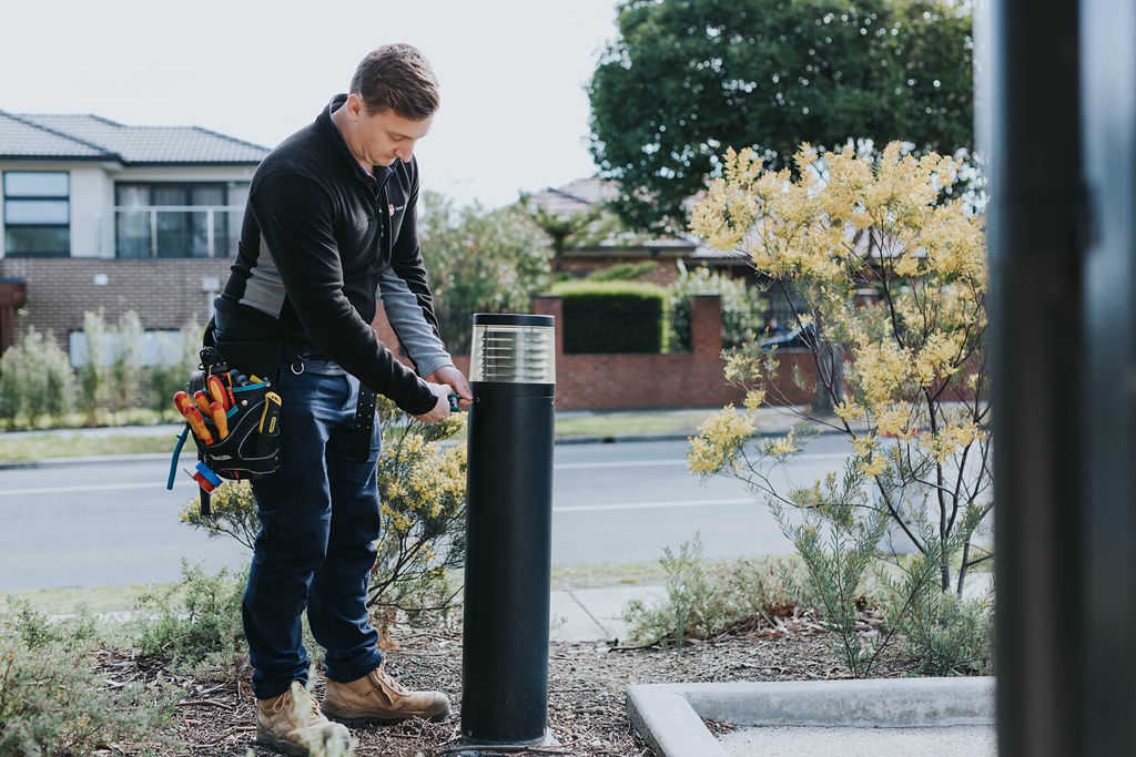 Electrician installing outdoor lighting bollard