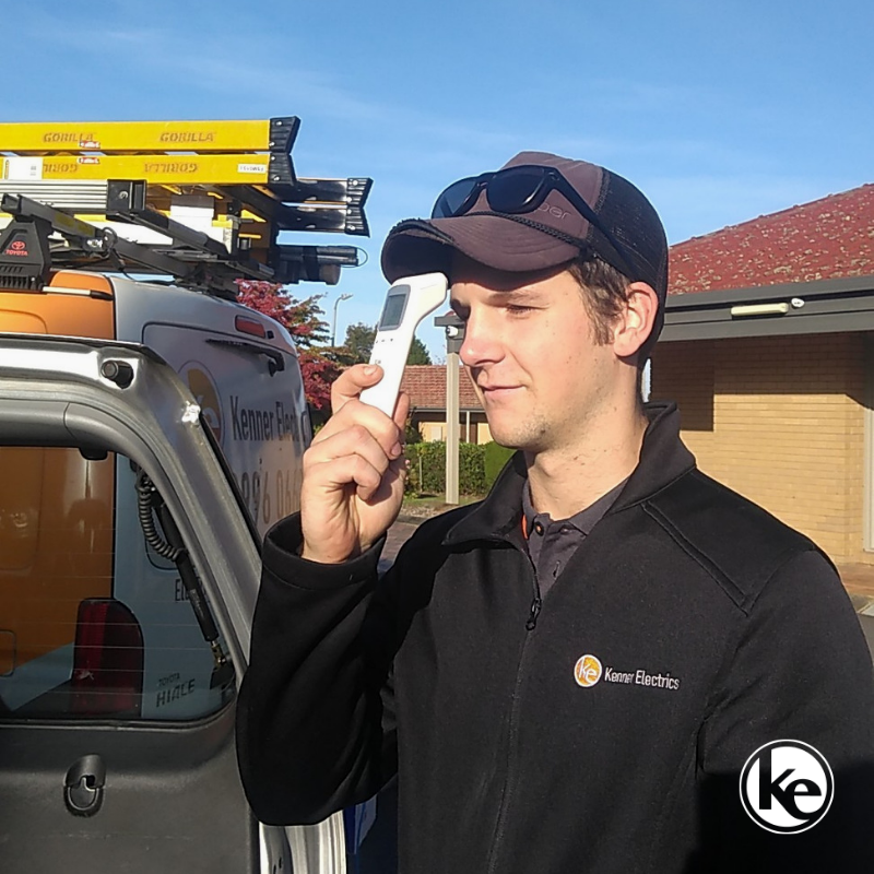 Electrician measuring their temperature during COVID pandemic