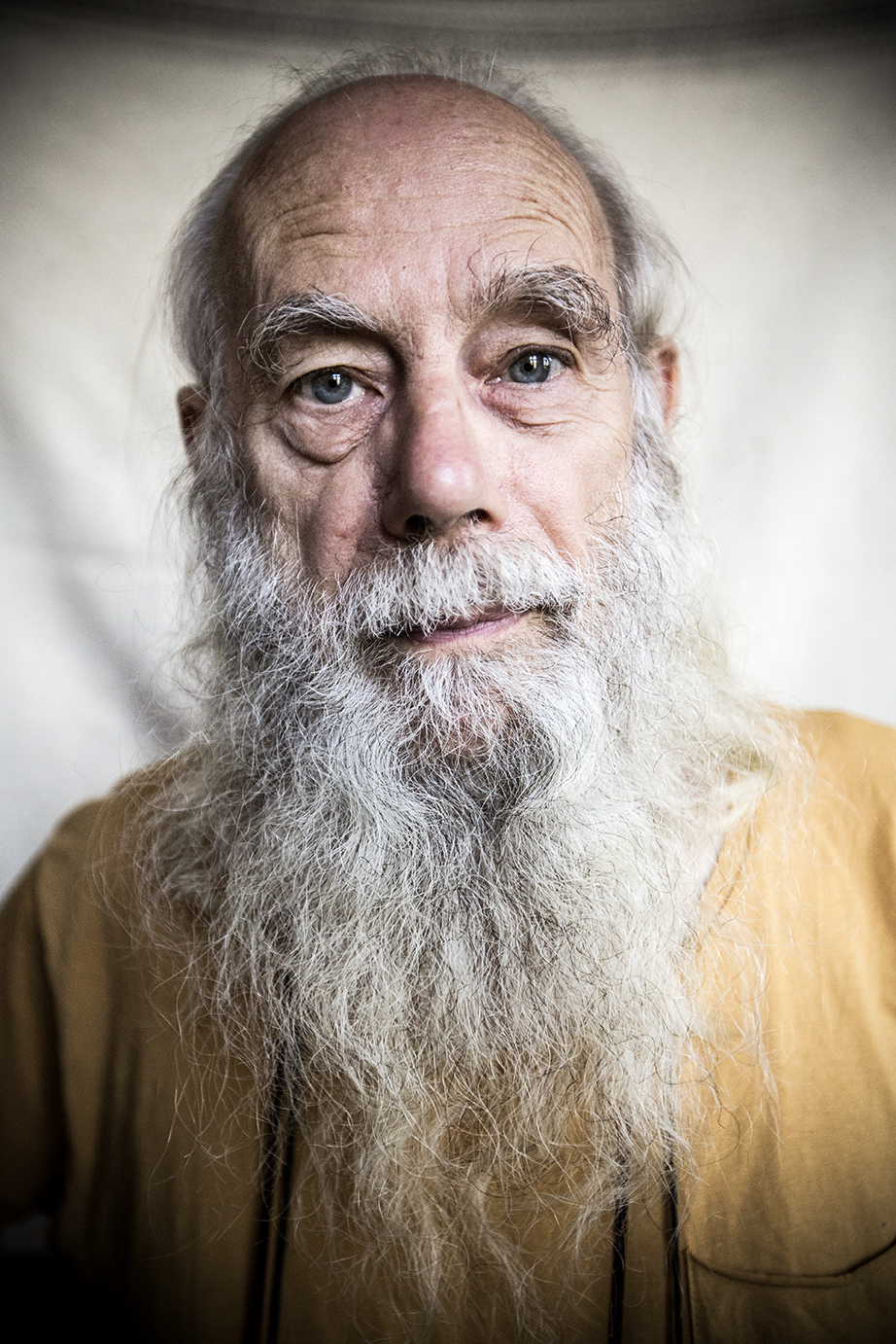 A man in his sixties with white hair and a long beard stares intently into the calendar.