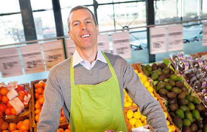 Grocery employee stocking fruit