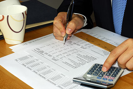 Businessman reviewing financial data with a calculator