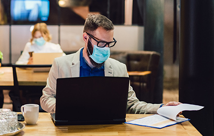 Businessman wearing a mask while working at his desk