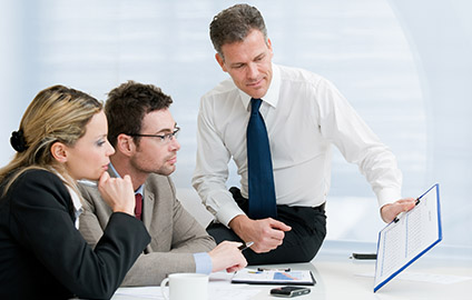Advisor showing a pair of business people financial data