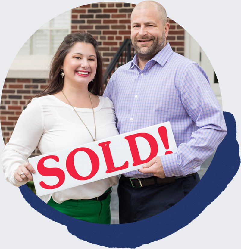 Tiffani and Brett hold a sold sign for a home