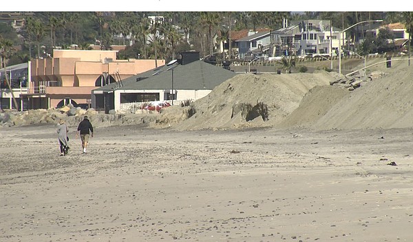 A couple walks along the beach in Encinitas, Feb. 27, 2019.