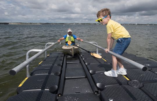 Five-year-old Kelvin Hall helps Dave Barker put his kayak into the water Tuesday at the newly renovated Navarre Beach Marine Park. Santa Rosa County officials unveiled the improved ADA-friendly park to the public during a ceremony earlier in the day.
