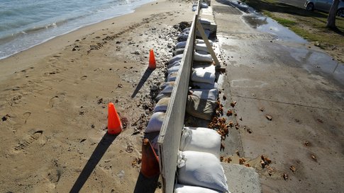 In this June 23, 2017 photo, sand bags line the beach at Ala Moana Beach Park in Honolulu as record high tides hit the islands. Some of Hawaii's most iconic beaches could soon be underwater as rising sea levels caused by global warming overtake its white sand beaches and bustling city streets. That’s alarming for a state where beach tourism is the primary economic driver. (Honolulu Star-Advertiser, Bruce Asato via AP)
