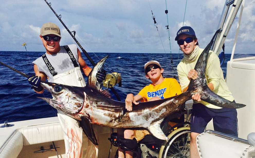Logan Prickett, center, flanked by mate Colby Mason, left, and Captain Nick Stanczyk, right, show off a 105-pound swordfish that Prickett caught off the Florida Keys using an electric-assist fishing reel. Associated Press (2004)