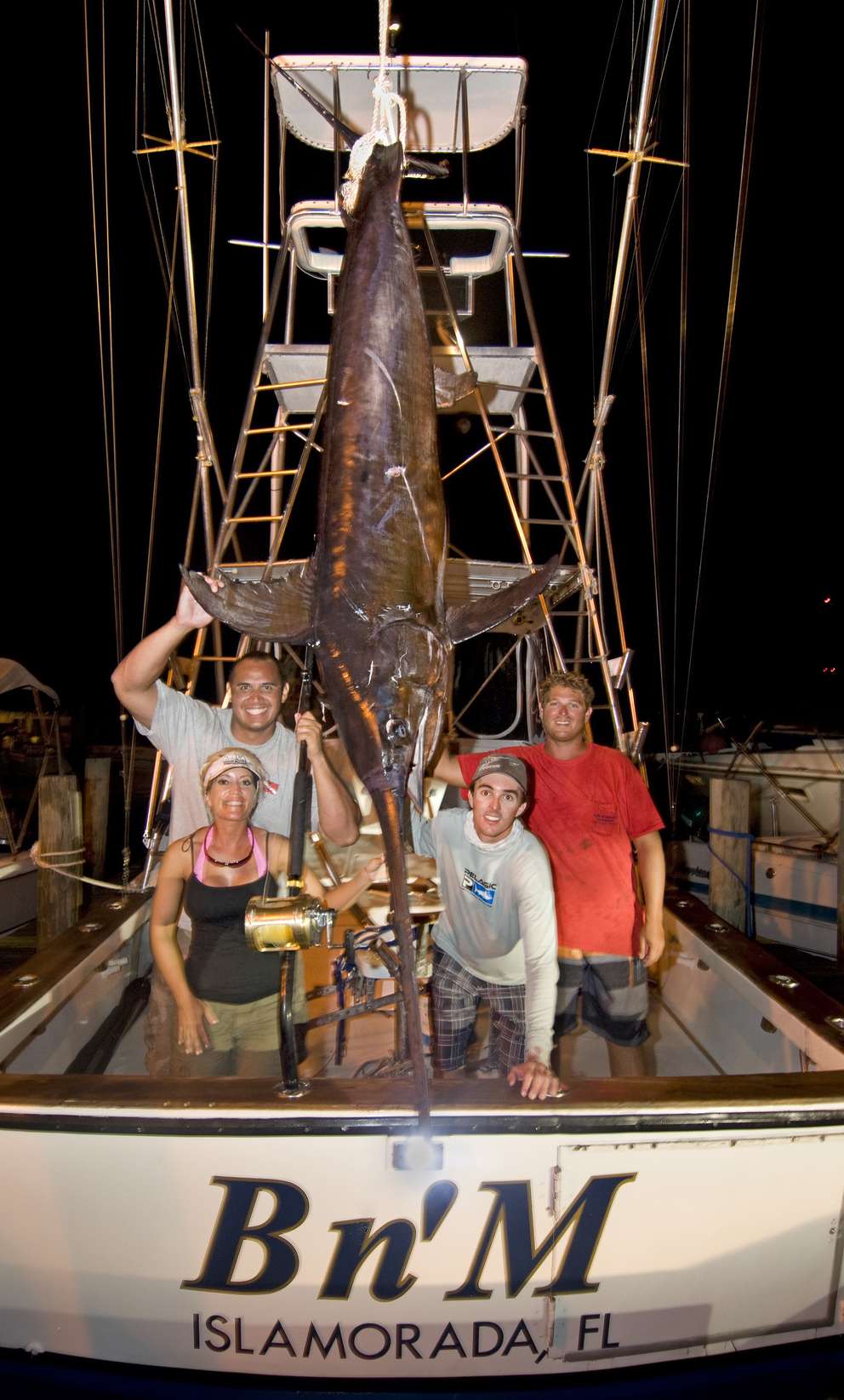 In this Sept. 24, 2011 photo provided by the Florida Keys News Bureau, John White, top left, shows off a 455-pound swordfish back at the dock in Islamorada, Fla. To the right of the fish is Captain Nick Stanczyk, left, and mate Matt Davis. The fish was caught 30 miles south of Islamorada and took five hours to boat. Associated Press (2011)