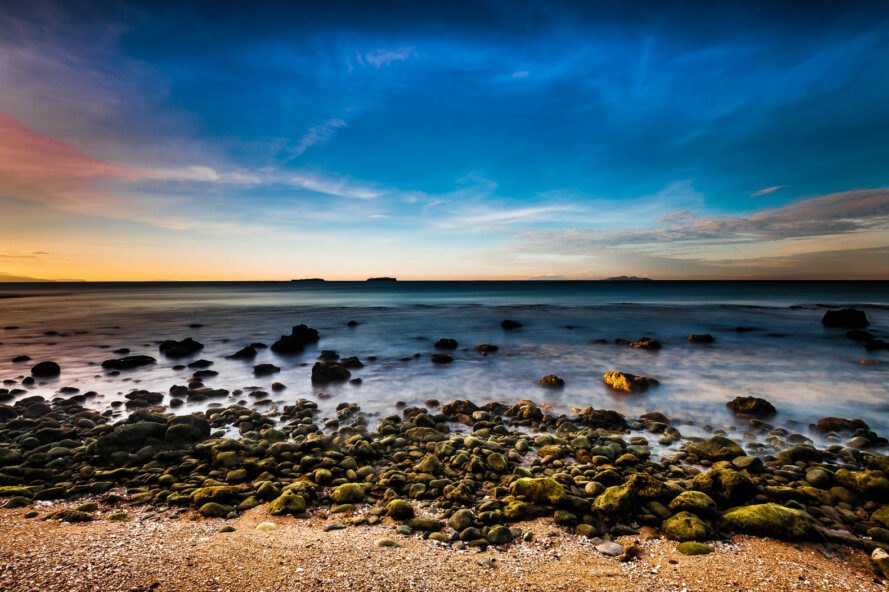 Crisp, clear beach with rocks in the Philippines during a colorful sunset