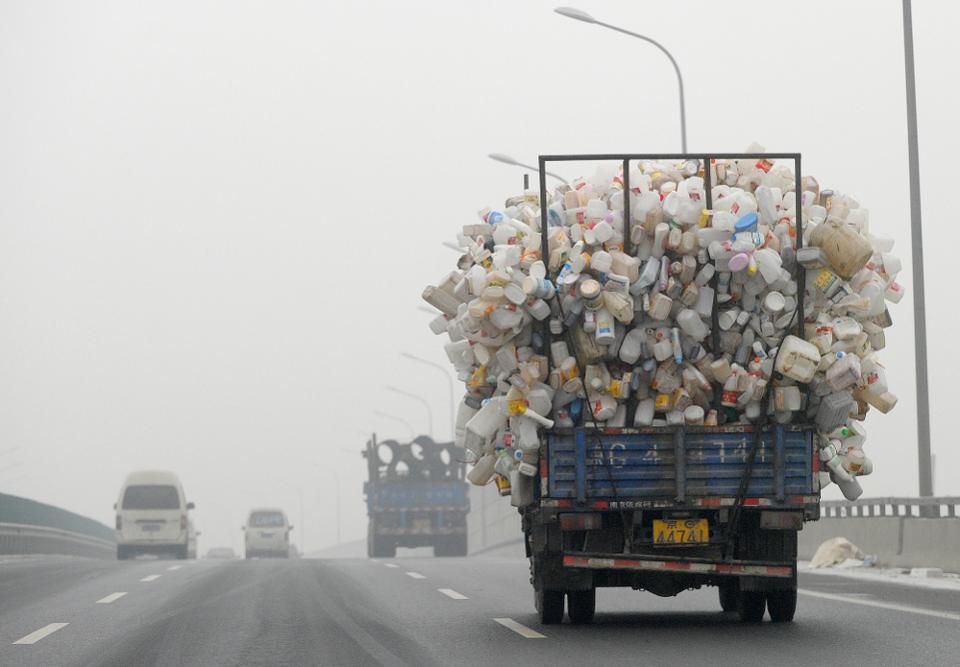 A truck containing used plastic bottles travels along a hazy highway in Beijing (Credit: LIU JIN/AFP/Getty Images)