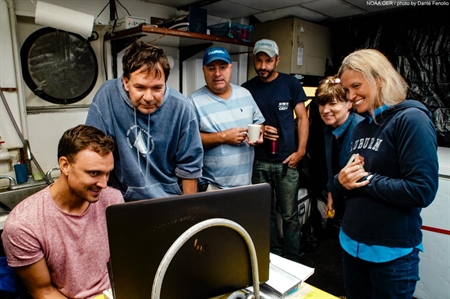 Left to right: Nathan Robinson, Sonke Johnsen, Tracey Sutton, Nick Allen, Edie Widder, and Megan McCall gather around to watch the squid video. Image courtesy of Danté Fenolio.