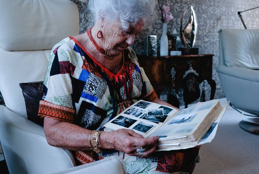 Mina Verton looks through a scrapbook of family photos at her home in Zierikzee.