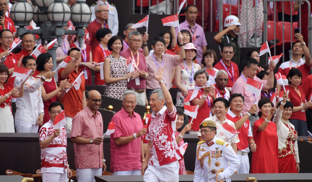 Prime Minister Lee Hsien Loong (front C) waves as he arrives for the 54th National Day Parade in Singapore. Photo: AFP