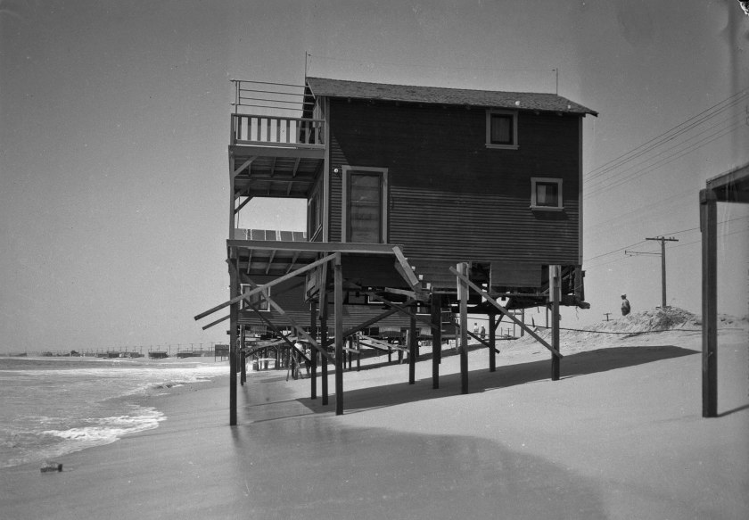 A beach house on stilts at water’s edge at Newport Beach.