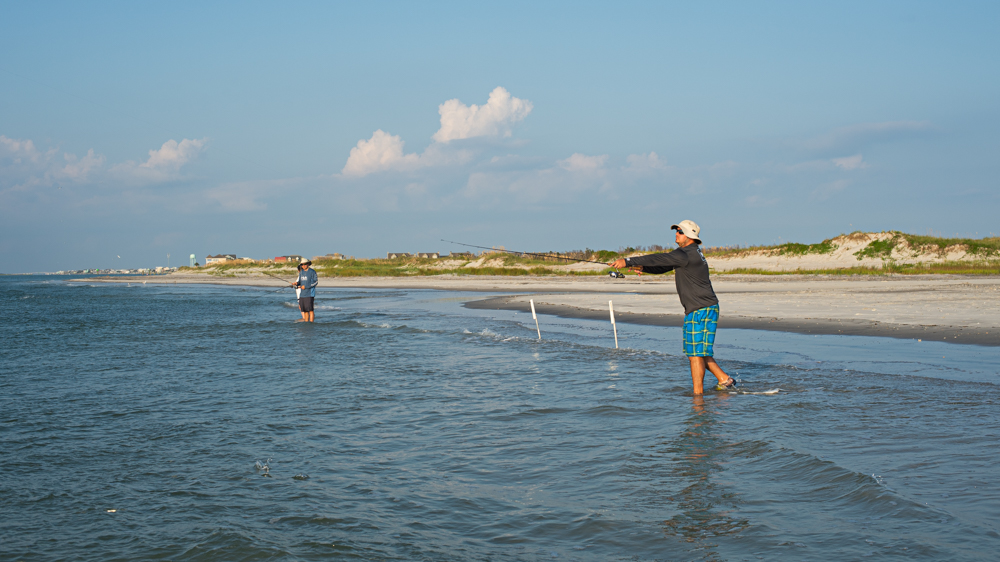 Jason Bologna, visiting from Pittsburgh, throws a line out while fishing along the shoreline of the southern point of Topsail Island Tuesday evening. (Port City Daily photo/Mark Darrough)