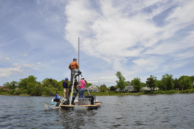 Jeffrey Donnelly, in the orange jacket, and his team collect a sediment core from a coastal pond. Photo courtesy of Jeffrey Donnelly
