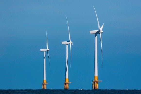 Three offshore wind turbines in the distance.