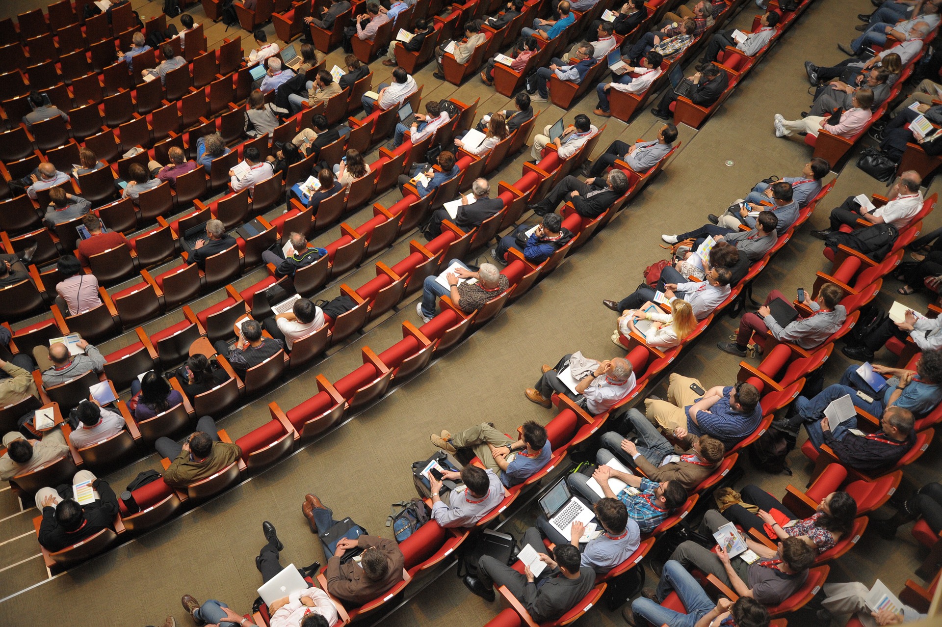 people taking notes in large lecture hall