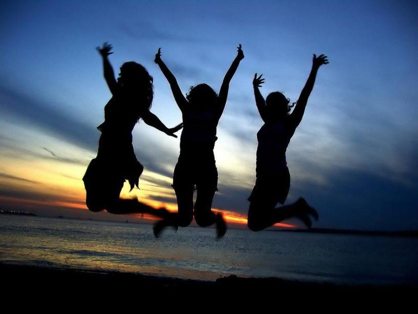 3 silhouettes jumping on a beach