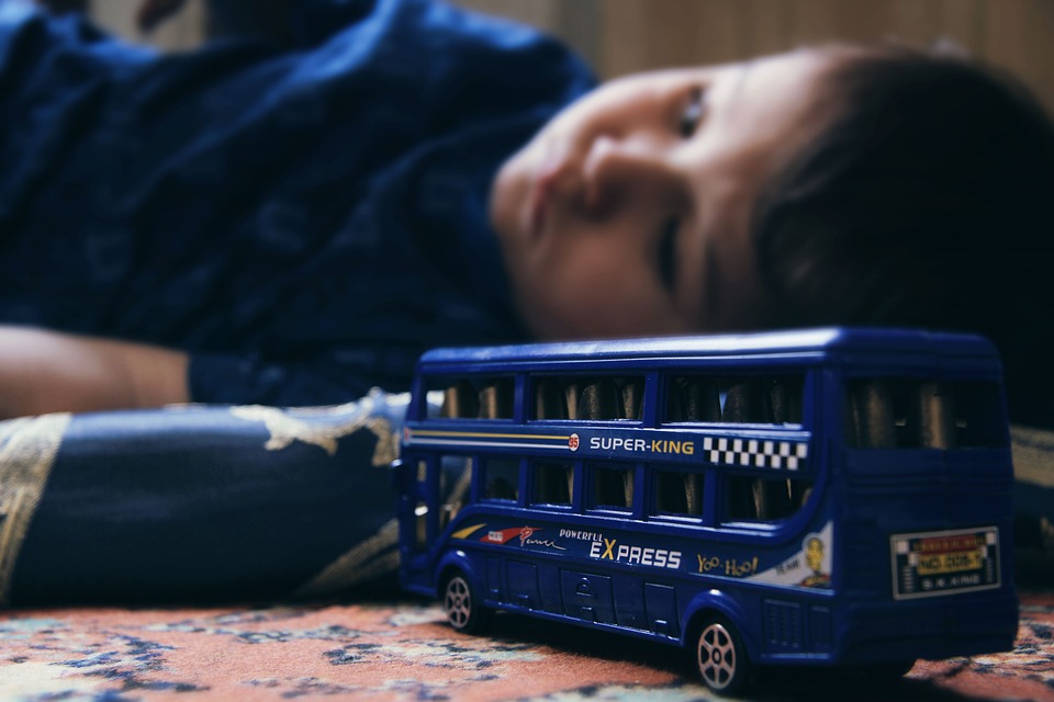 Young boy lies on floor, uninterested in the toy in front of him.