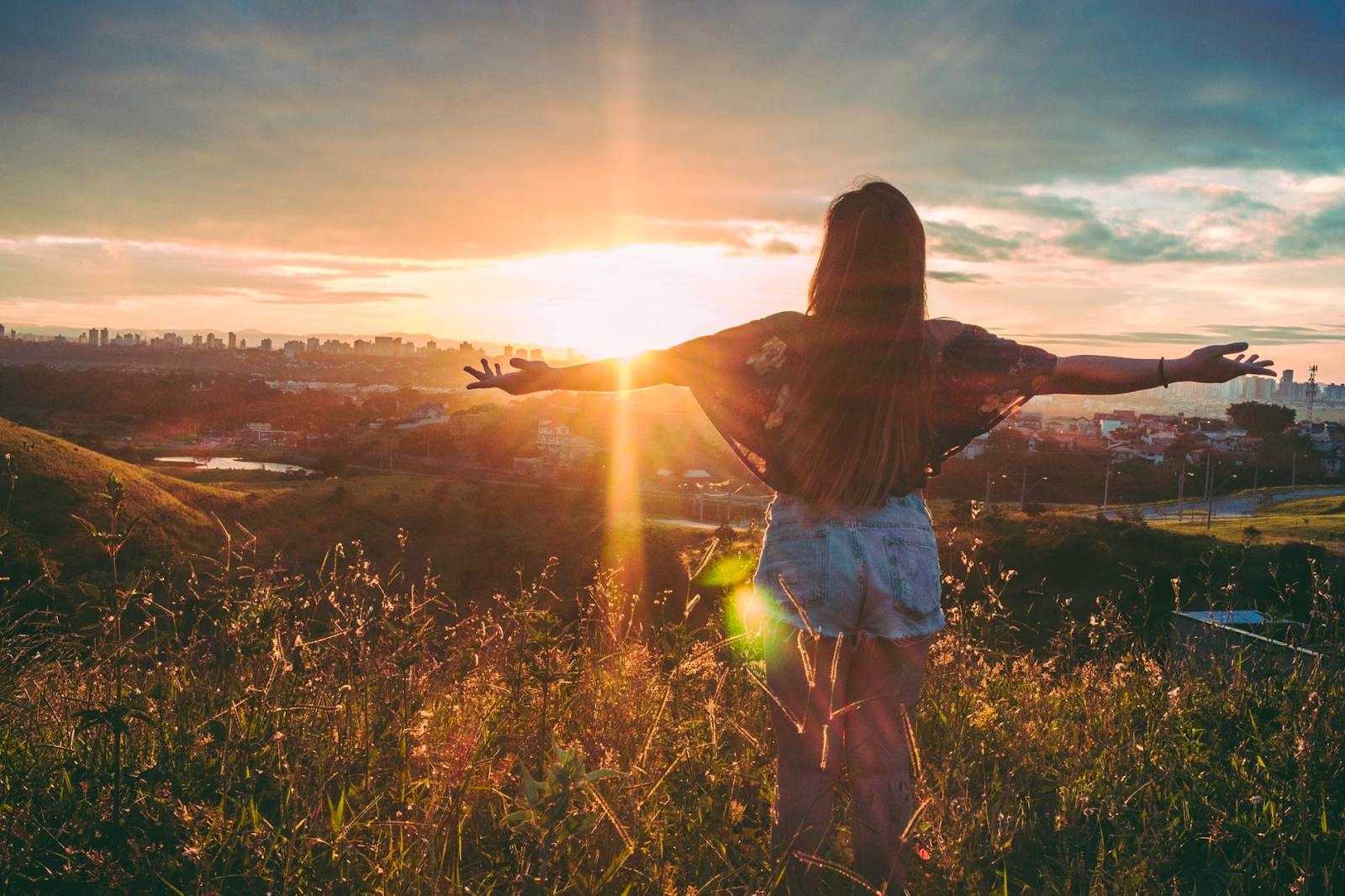 woman with outstretched hands watching sunrise