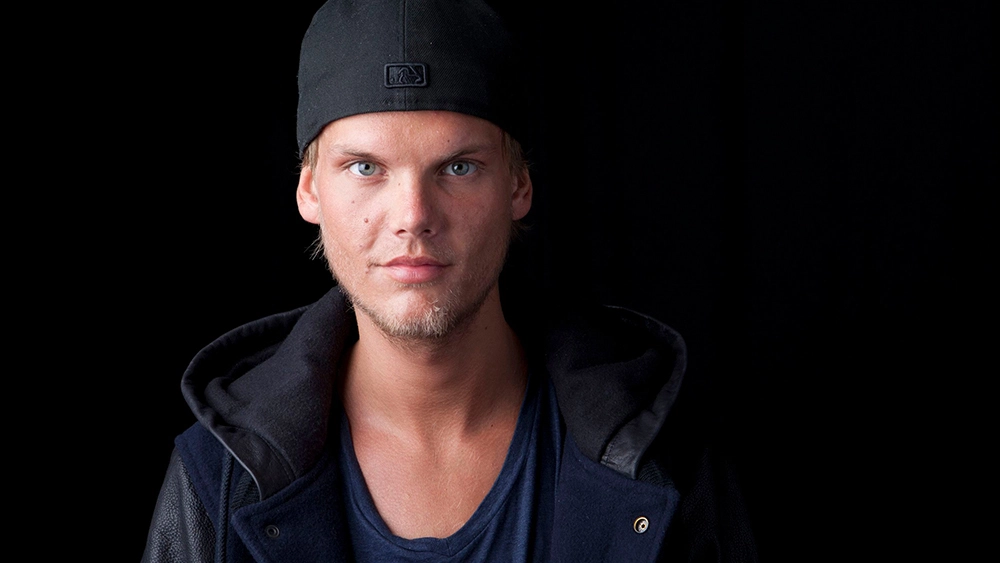 Deceased singer Avicii against a black background looking into the camera prior to mental health crisis