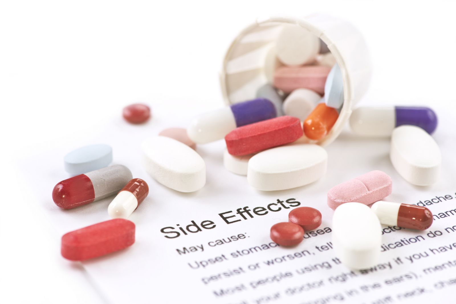 Pills on top of a paper that reads "side effects"