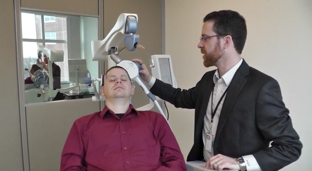Technician administers TMS through electromagnetic coil.