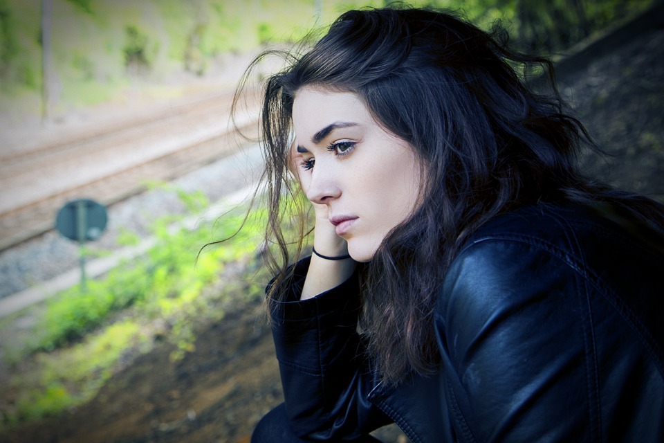 Girl with depression is distracted outside