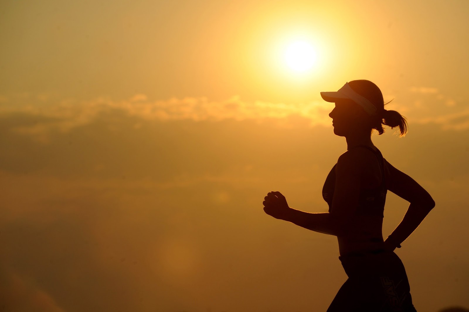 The silhouette of a woman exercising in the morning to help treat her insomnia.