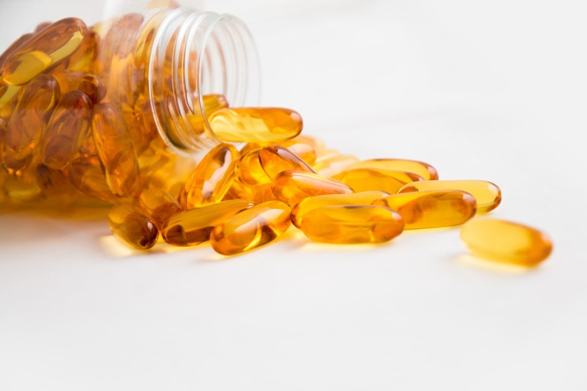 On a table is a bottle of fish oil capsules, which are good supplements to take for managing how your memory functions.