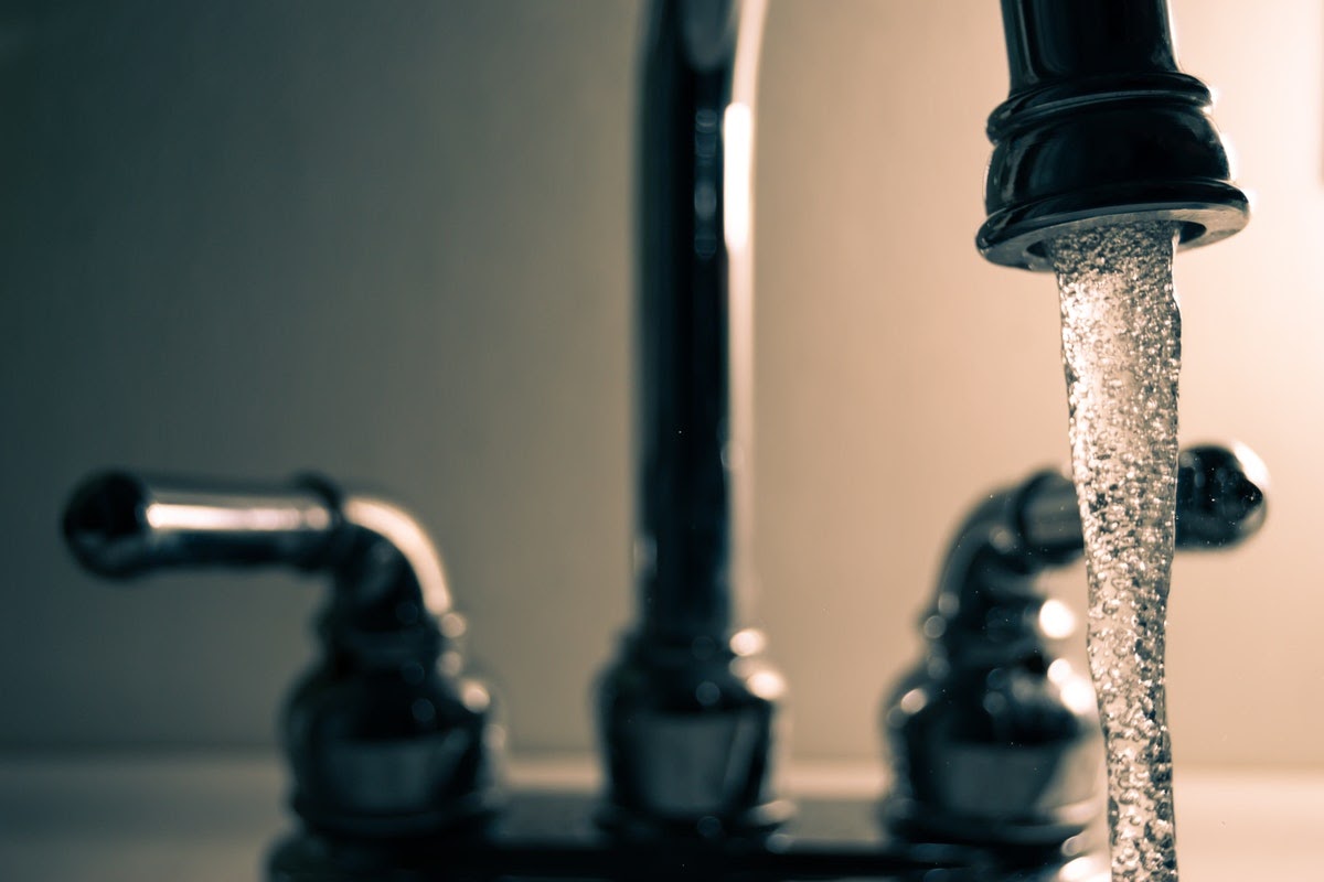 Pictured is a sink with the cold water running. One great grounding exercise for bringing yourself back into the present moment is to run your hands under cold water.