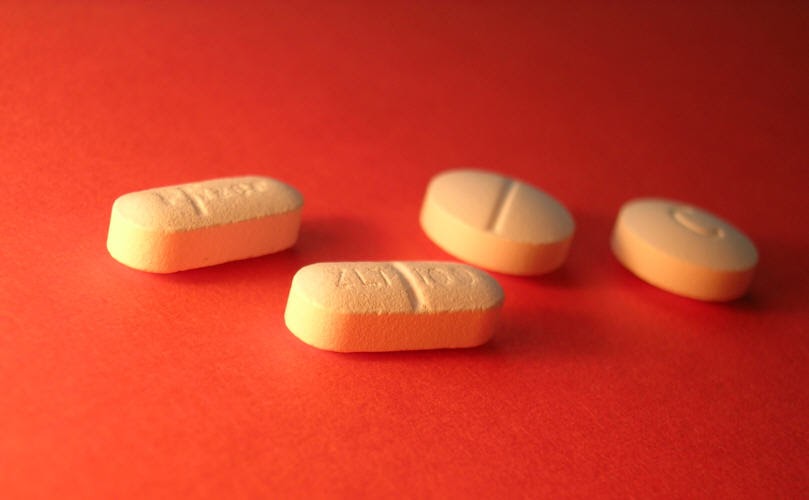Antidepressant pills, including Zoloft, sit on a table.