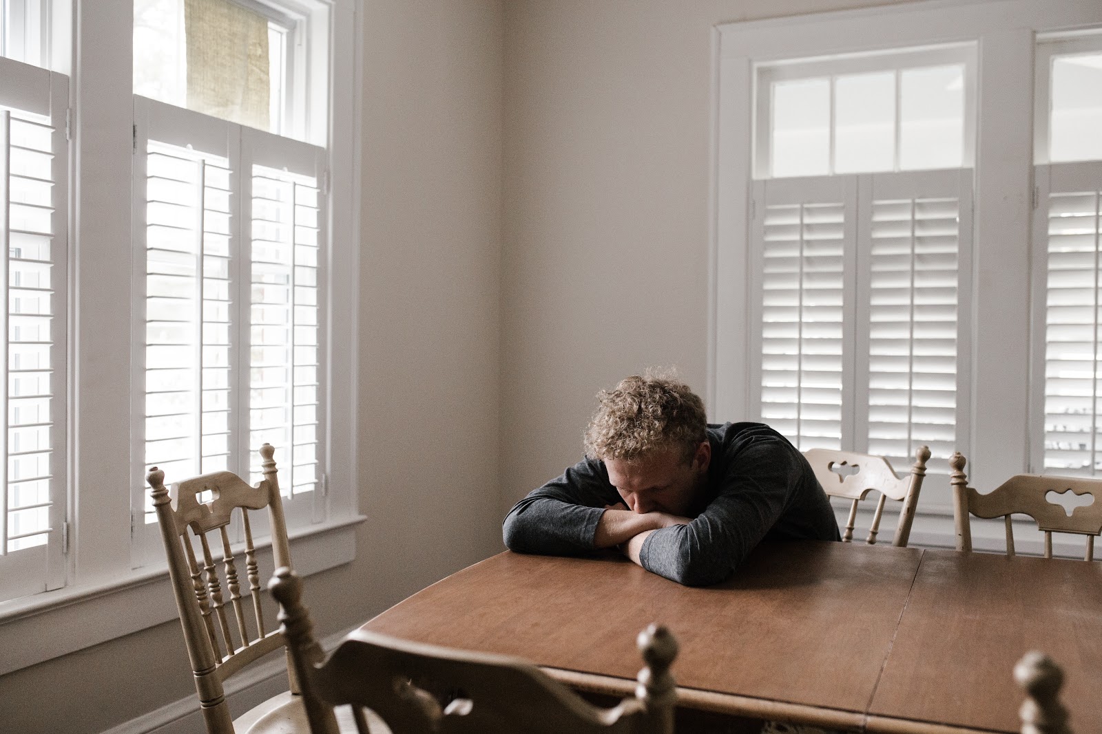 Sad man putting head down on a table