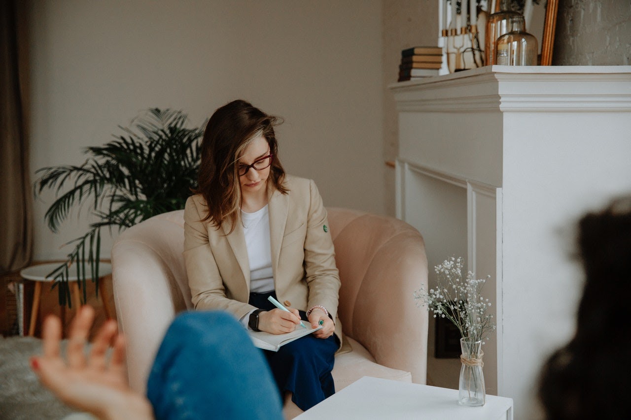 Therapist writes in a journal during a session